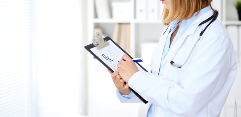 Doctor Looking at Clipboard Assessing a Workers' Compensation Claim